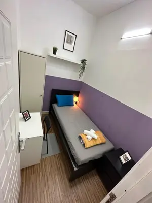 a small room with a bed with a purple wall at Prime Partition Room in Al Barsha 1 Near Metro in Dubai