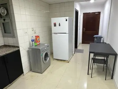 a kitchen with a washing machine and a refrigerator at Short Stay Partition Room in Al Barsha 1 Near Mashreq Metro in Dubai