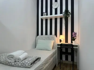 a room with a bed and a table with towels at Beautiful Partition Strip Room in Barsha Heights in Dubai