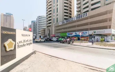a street in a city with a sign and buildings at Beautiful Partition Strip Room in Barsha Heights in Dubai