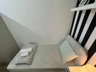 a small bed in a corner of a room at Beautiful Partition Strip Room in Barsha Heights in Dubai