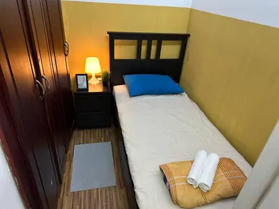 a small bedroom with a bed with two towels on it at Cozy Partition Room Near Mashreq & MOE Metro in Dubai