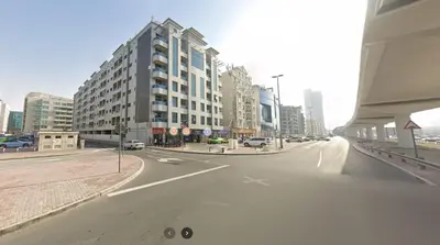 an empty street in a city with tall buildings at Cozy Partition Room Near Mashreq & MOE Metro in Dubai