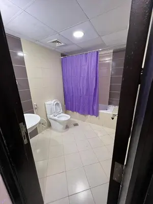 a bathroom with a toilet and a purple shower curtain at Cozy Partition Room Near Mashreq & MOE Metro in Dubai