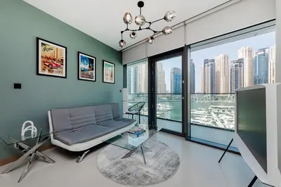 a living room with a couch and a large window at Luxurious 2BR apt with panoramic Marina view in Dubai