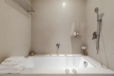 a white bath tub in a white bathroom with towels at Luxurious 2BR apt with panoramic Marina view in Dubai