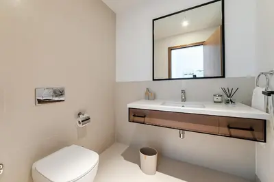 a bathroom with a toilet and a sink and a mirror at Luxurious 2BR apt with panoramic Marina view in Dubai