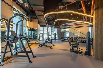 a gym with rows of treadmills and machines at Ranch Living 1 bedroom apartment in Business Bay by Suiteable in Dubai