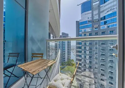 a balcony with a table and chairs and a view of a city at First Class Apartments in Seven Palm with direct Access to the West Palm Beach and Nakheel Mall in Dubai