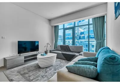 a living room with a couch and a tv at First Class Apartments in Seven Palm with direct Access to the West Palm Beach and Nakheel Mall in Dubai