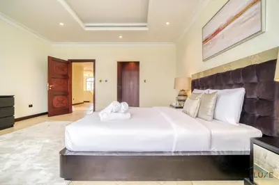 a bedroom with a large white bed in a room at Premier 6BR Villa with Assistant's Room and Private Pool in Frond E Palm Jumeirah by Deluxe Holiday Homes in Dubai