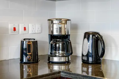a coffeemaker and a coffee maker on a counter at Cute 1 BR - Walk to Opera, Mall & Burj Khalifa in Dubai