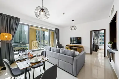 a living room with a couch and a table at Cute 1 BR - Walk to Opera, Mall & Burj Khalifa in Dubai