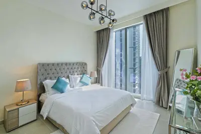 a bedroom with a bed and a large window at Chic 2-Bedroom Downtown Gem in Dubai