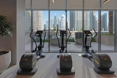 a row of treadmills in a gym with a view of the city at Chic 2-Bedroom Downtown Gem in Dubai