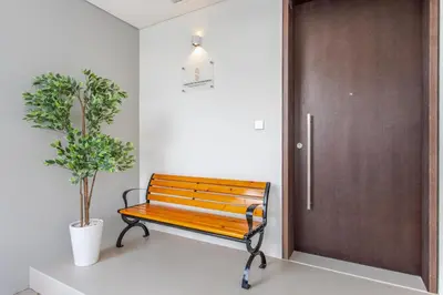 a wooden bench next to a door with a potted plant at Three Bedroom Villa with Maid Room in Tilal Al Ghaf by The S Holiday Homes in Dubai
