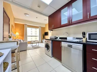 a kitchen with a washer and dryer in a room at Sun, Sand, and FUN - King Bed, Sofa Bed! Sleeps 4 in Dubai
