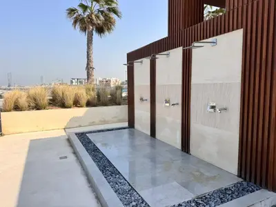 a bathroom with a shower with a palm tree in the background at Spacious 1 bed in La Mer - 1 min to the beach in Dubai