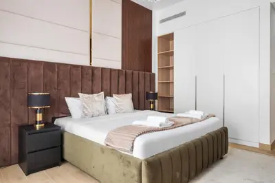 a bedroom with a large bed with a wooden headboard at Spacious 1 bed in La Mer - 1 min to the beach in Dubai