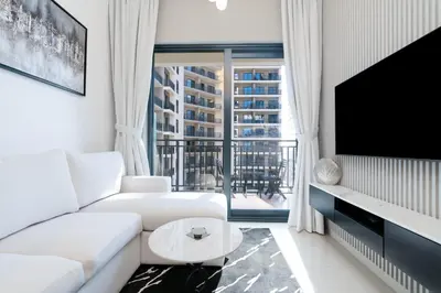 a living room with a white couch and a large window at Stylish Apartment in Dubai