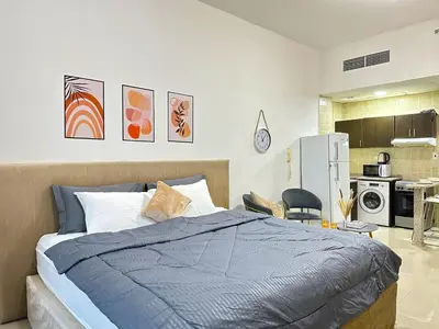 a bedroom with a bed and a kitchen at Comfy Studio w/ Balcony & Nice Design in Marina in Dubai