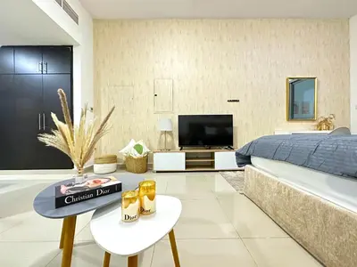 a living room with a bed and a tv at Comfy Studio w/ Balcony & Nice Design in Marina in Dubai