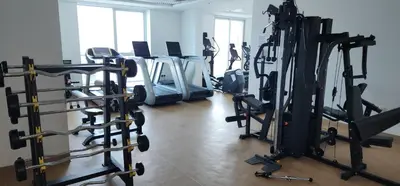 a gym with rows of treadmills and machines at Preatoni Tower - JLT by Golden Casa in Dubai