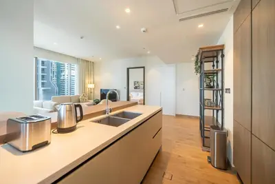a kitchen with a sink and a living room at Luton Vacation Homes - Tranquil 2BR Haven in the Heart of Dubai Marina- 28AB04 in Dubai