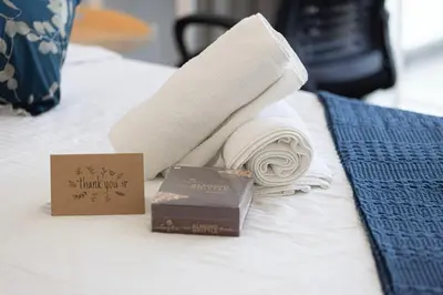 a towel and a bar of chocolate on a bed at Cozy Studio 29th Floor, Bloom Towers Marina View in Dubai