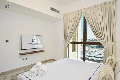 a bedroom with a bed and a large window at Luxury Escapes - Contemporary 2BR Gem in Madinat Jumeirah - RAHAAL in Dubai