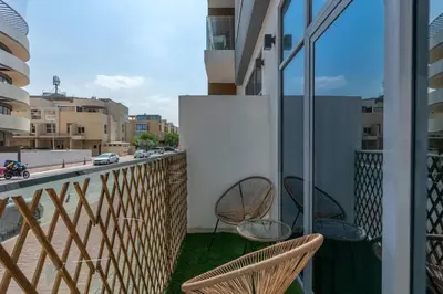 a balcony with two chairs and a view of a street at Nice Studio in heart of JVC - Pantheon Elysée - Dubai in Dubai