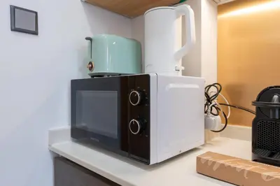 a microwave oven sitting on top of a counter at Nice Studio in heart of JVC - Pantheon Elysée - Dubai in Dubai
