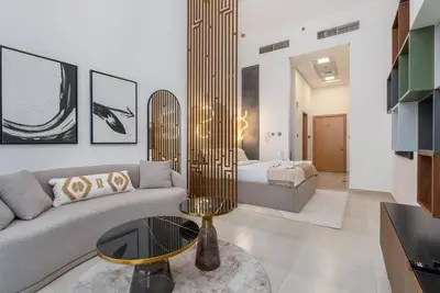 a living room with a couch and a bed at Nice Studio in heart of JVC - Pantheon Elysée - Dubai in Dubai