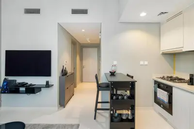 a kitchen with a bar and a tv on a wall at 1 Bedroom in Zada Tower - Business Bay - Dubai in Dubai