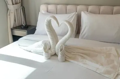 two white swans making a heart on a bed at 1 Bedroom in Zada Tower - Business Bay - Dubai in Dubai