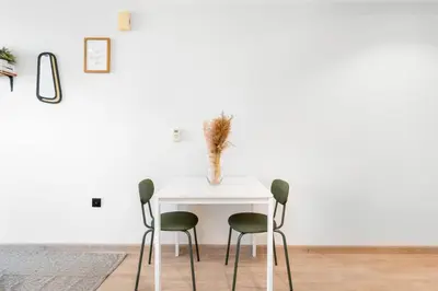 a white table with two chairs and a vase on it at Studio with Burj Khalifa View in Dubai