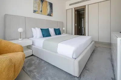 a bedroom with a large white bed with blue pillows at Frank Porter - Bluebell Residence in Dubai