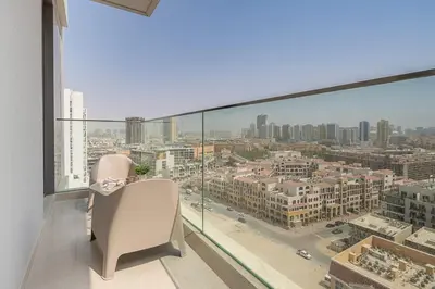 a balcony with two chairs and a view of a city at Frank Porter - Bluebell Residence JVC in Dubai