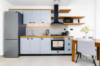 a kitchen with white cabinets and a stove at Chic Bright One Bedroom Suite in Dubai