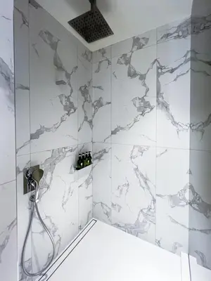 a bathroom with a shower with white marble tiles at #37 Luxury - 2BR in The Address Dubai Opera - Downtown in Dubai