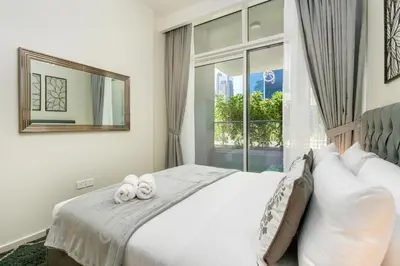 a bedroom with a bed with two towels on it at White Sage- Damac Vera Residences 417 in Dubai