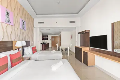 a hotel room with two beds and a flat screen tv at Great 2BR APT Ocean Heights in Dubai