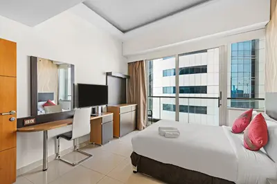 a hotel room with a bed and a desk with a computer at Great 2BR APT Ocean Heights in Dubai