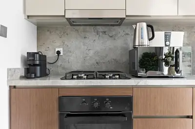 a kitchen with a stove and a coffee maker at StoneTree - Luxurious with Private Beach Access in Dubai