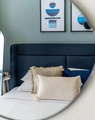 a bed with a black headboard and pillows on it at GuestReady - Vibrant Retreat in Dubai's Heart in Dubai