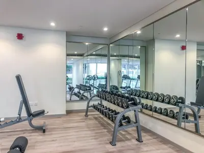 a gym with rows of treadmills and mirrors at GuestReady - Vibrant Retreat in Dubai's Heart in Dubai