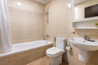 a bathroom with a toilet and a sink and a bath tub at GuestReady Holiday Homes - Urban Elegance in JLT in Dubai