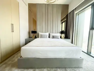 a bedroom with a large white bed and large windows at Luxury Burj Royale Apt Balcony Burj Khalifa View in Dubai