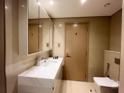 a bathroom with a large white sink and a mirror at Luxury Burj Royale Apt Balcony Burj Khalifa View in Dubai