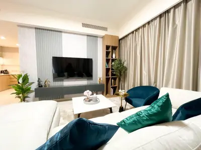 a living room with two white couches and a tv at Luxury Burj Royale Apt Balcony Burj Khalifa View in Dubai